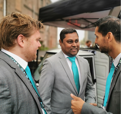 Three salesmen in suits at a company event