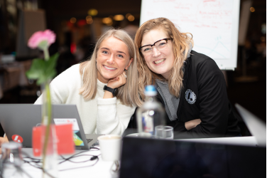 Two smiling female employees during our hackathon